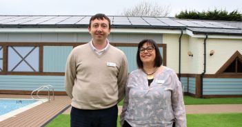 image of Justin Smith and Miranda Jacobs with solar panels at one of The Waterside Holiday Group's parks
