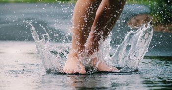 image of bare feet splashing in the water