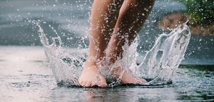 image of bare feet splashing in the water