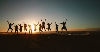 image of silhouettes of people celebrating in front of a sunset