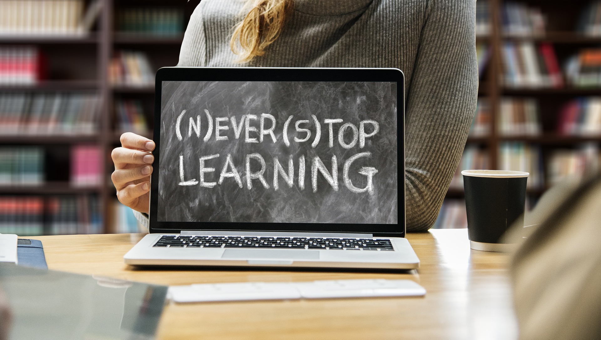 image of a laptop in a library that says 'never stop learning'