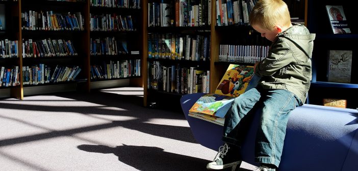 image of boy reading in a library