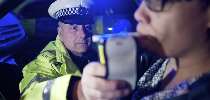 Policeman using a breathalyzer
